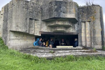 Vue la chambre de tir d'une casemate, à l'intérieur se trouve un petit groupe écoutant les explications du guide