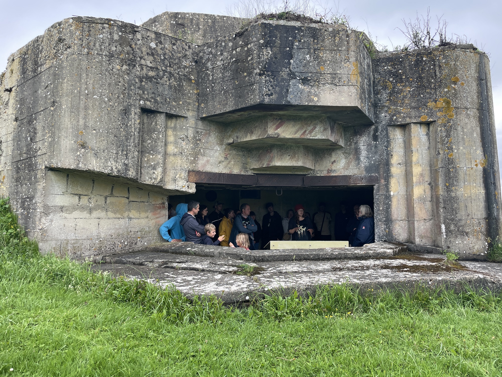 Vue la chambre de tir d'une casemate, à l'intérieur se trouve un petit groupe écoutant les explications du guide