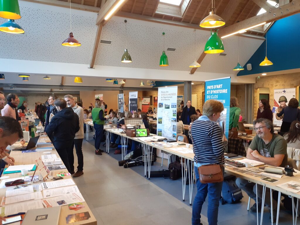 Dans une grande salle, nombreux stands d’information sur le patrimoine et la culture de la Manche
