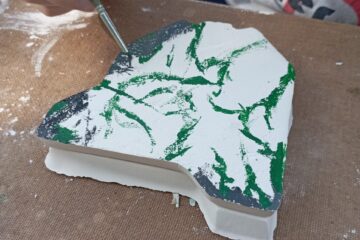 Enfant qui camoufle sa maquette en plâtre