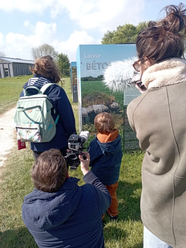 « Équipe de journalistes filmant un adulte et un enfant devant l’introduction de l’exposition Laisse Béton ? »